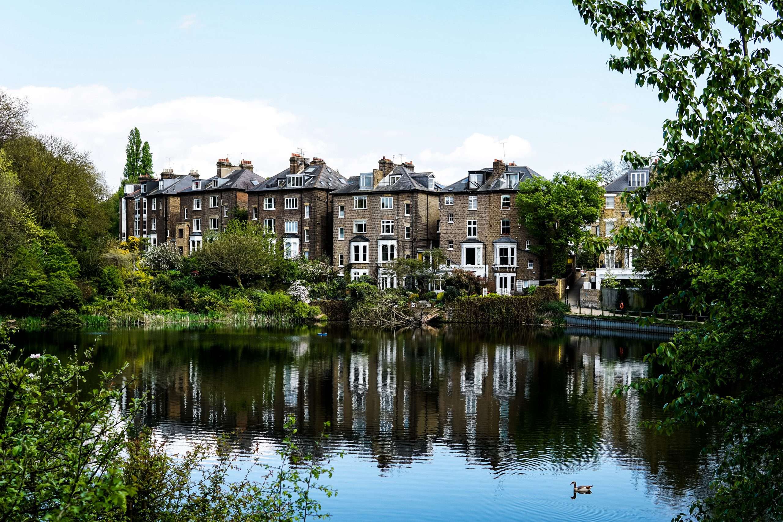 Residential homes along the edge of a pond or lake, visually representing an area with long term flood risks.