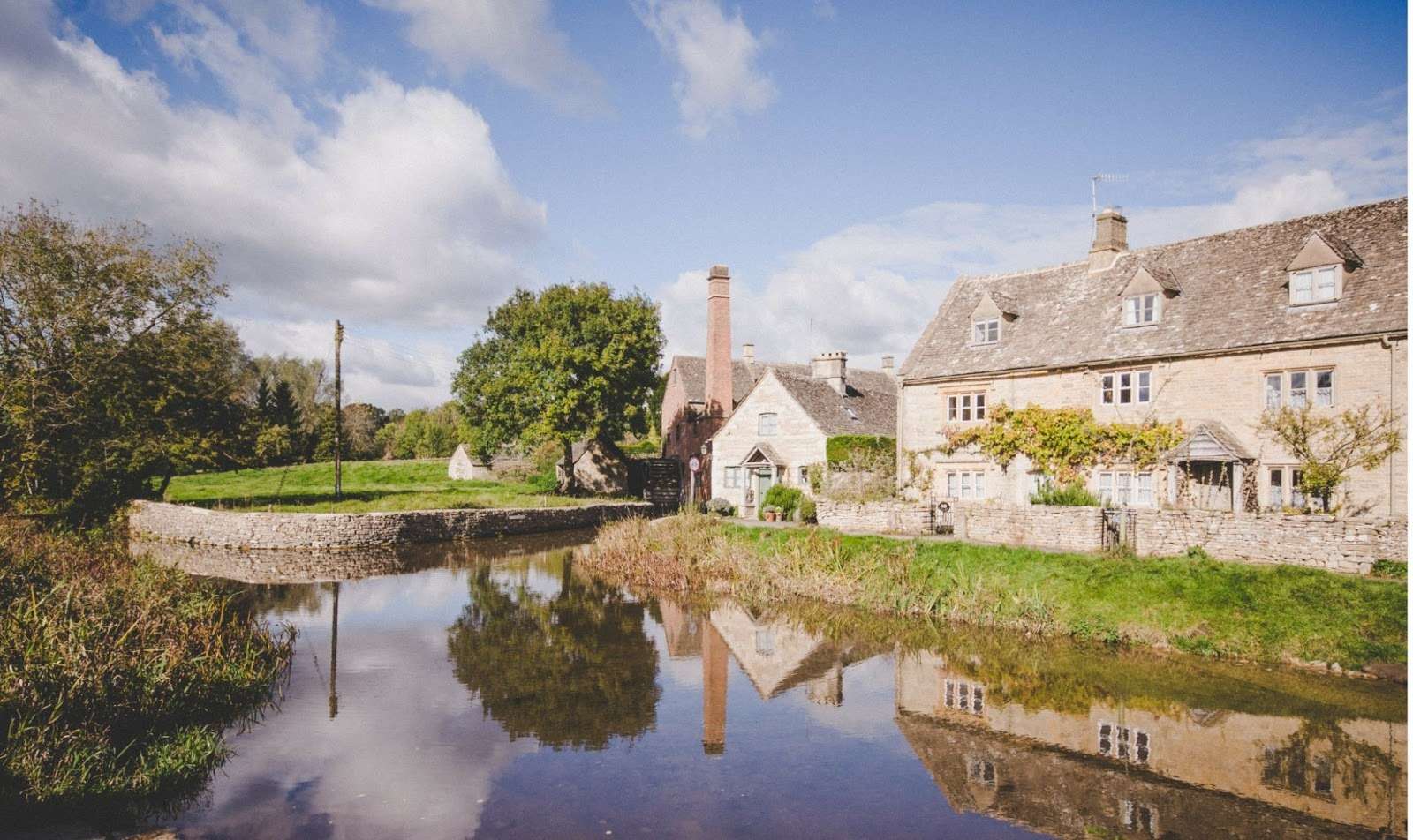 Traditional UK countryside homes beside a river in a low-lying rural area, illustrating typical UK flood areas.