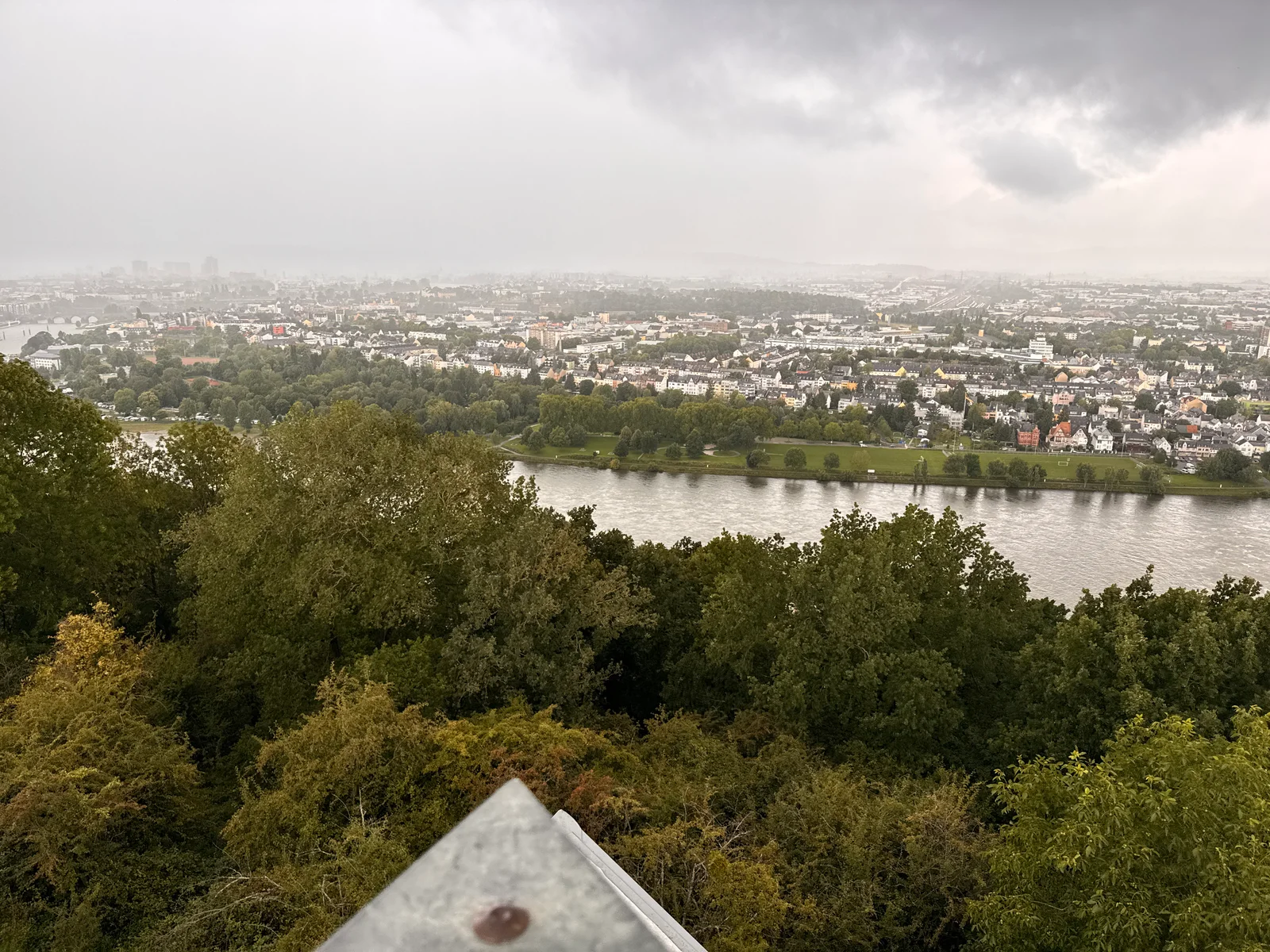 Elevated view of a river meandering through suburban landscape with dense urban development beyond.